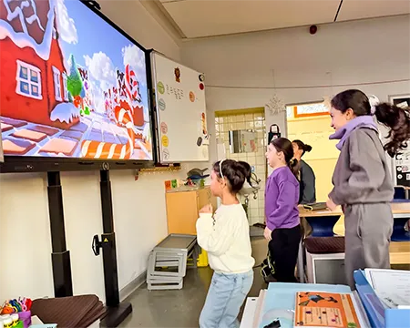 Kinder machen Bewegungsübungen vor der elektronischen Tafel