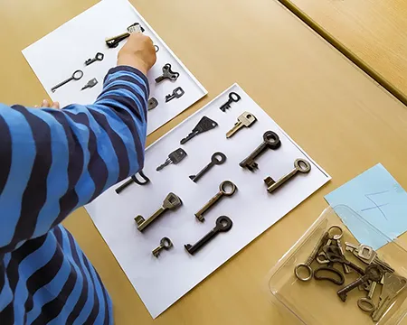 Schlüssel werden auf ein Blatt mit Abbildungen zusortiert